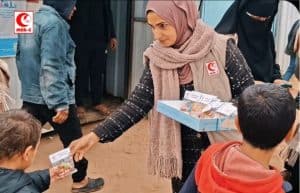 Relawan MER-C Indonesia membagikan bantuan kepada anak-anak di lokasi bencana.